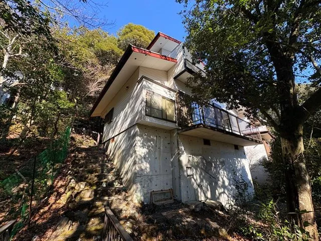 A detached house with a bus stop right in front and a view of the sea from an elevated position.