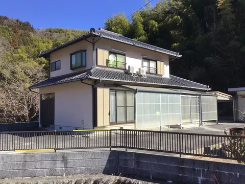 A garage with a shutter that can fit 3 cars, plus a separate building with a storage room. Asphalt