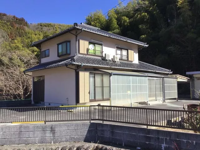 A garage with a shutter that can fit 3 cars, plus a separate building with a storage room. Asphalt