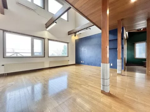 A 2-story used house located on an elevated area, with a spacious open ceiling.