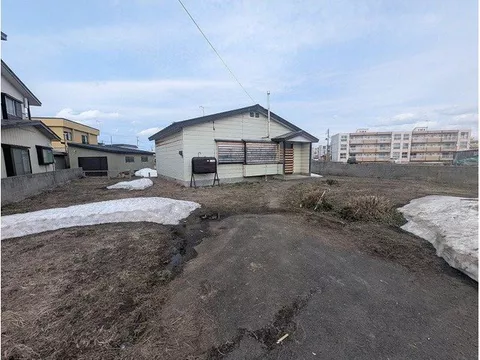 This is a single-story house that needs renovation. It has a large lot with a garden, and items are being removed.