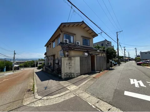 A well-lit residential building with a store located on a corner lot.